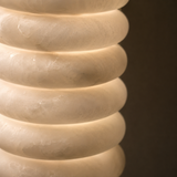 Close-up of a textured beige vase against a dark background
