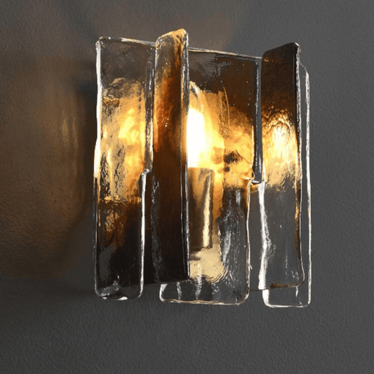 Decorative wall light fixture with glass panels on a dark background