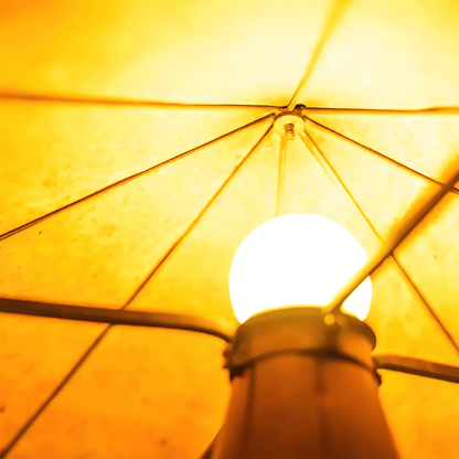 Close-up of a light bulb inside a yellow umbrella