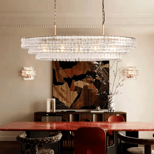 Chandelier hanging above a dining table with a wall art piece in the background.