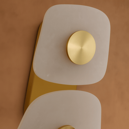 Decorative wall light fixture with gold and white design on a brown background