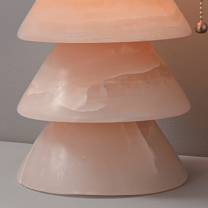Close-up of a pink lamp with a textured shade on a neutral background