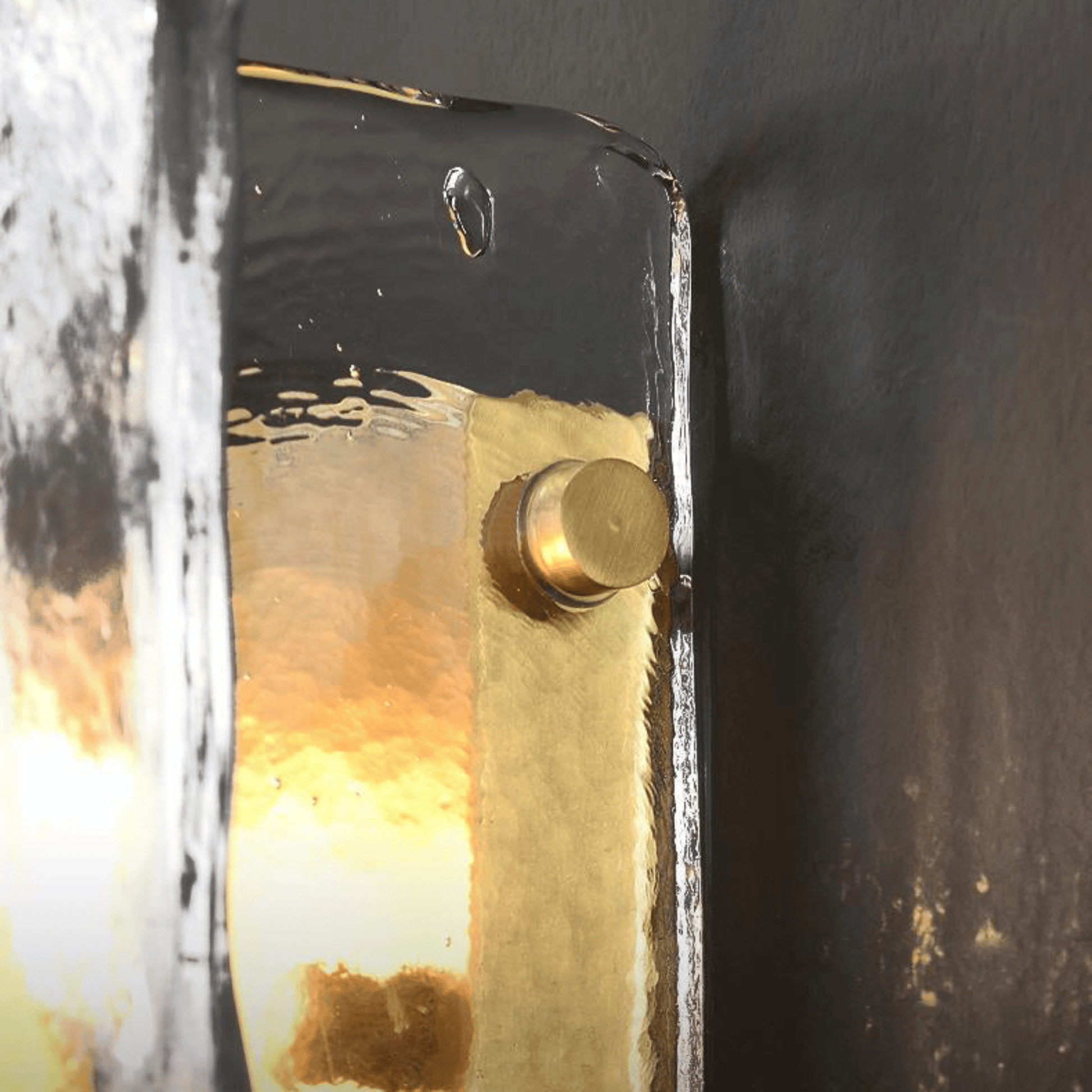 Close-up of a gold doorknob on a black door