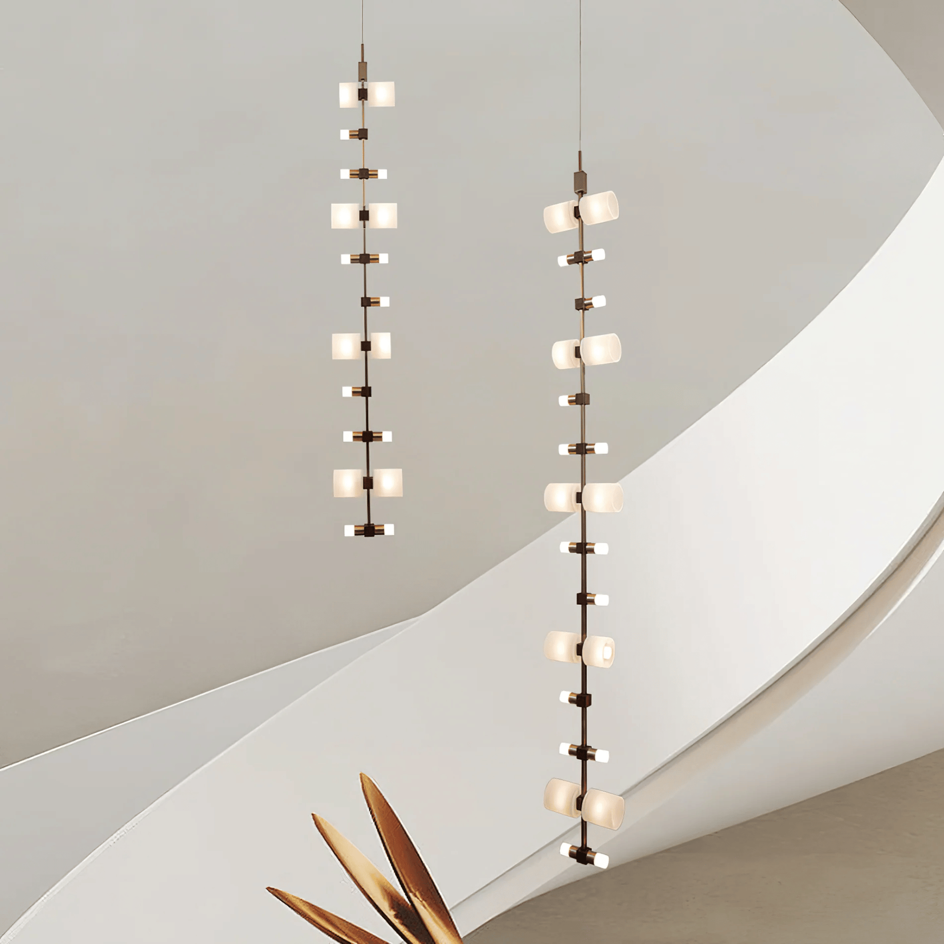 Two modern pendant lights hanging against a neutral wall.