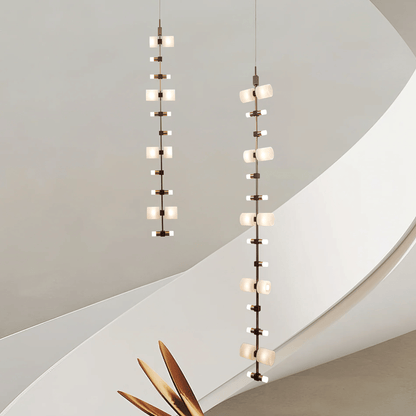 Two modern pendant lights hanging against a neutral wall.