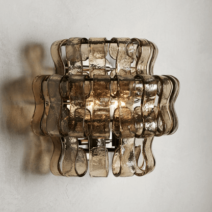 Decorative wall light fixture with wavy glass design on a plain background