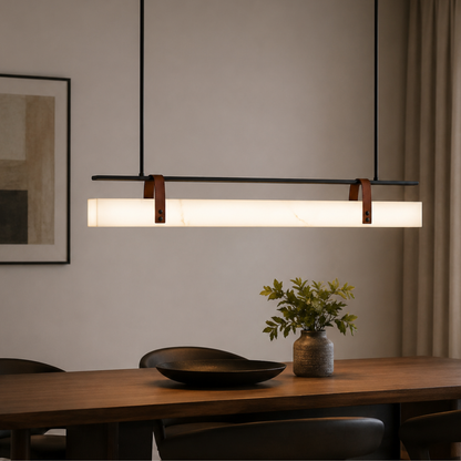 Modern pendant light over a dining table with decor items.