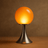 Table lamp with orange globe shade on a brown background