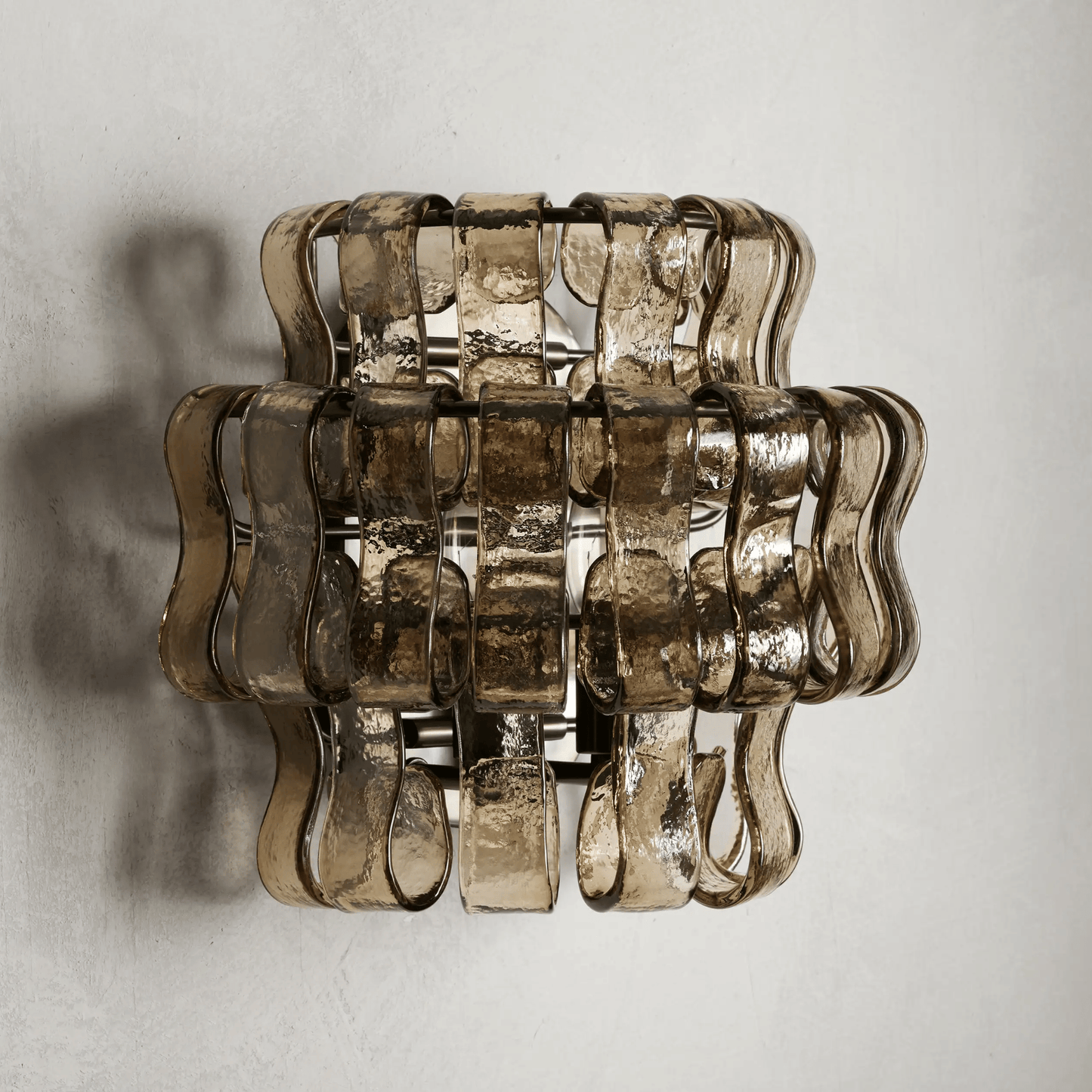 Decorative wall light fixture with wavy glass design on a plain background