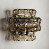Decorative wall light fixture with wavy glass design on a plain background