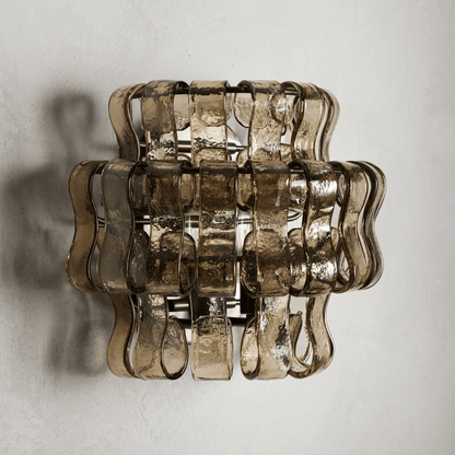 Decorative wall light fixture with wavy glass design on a plain background