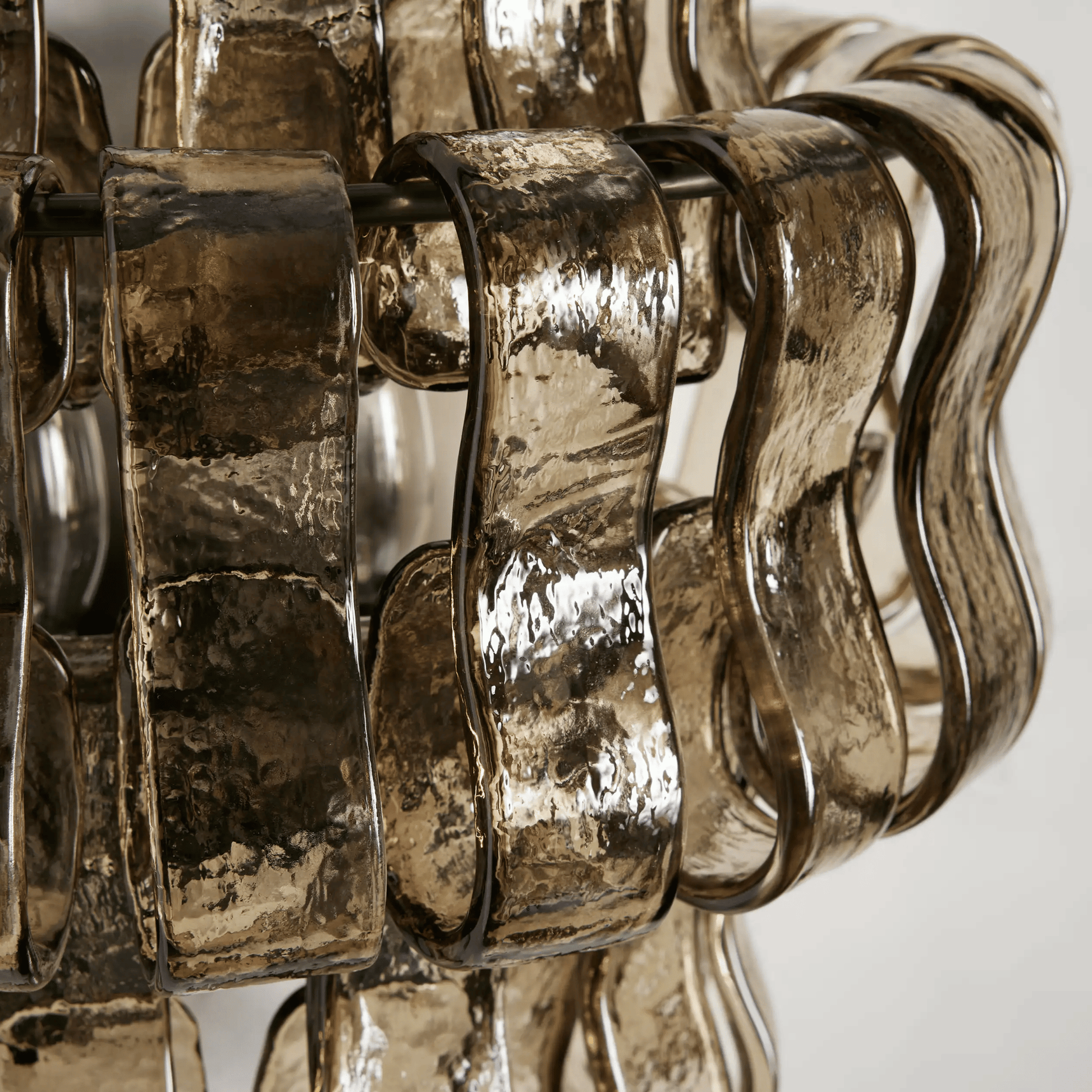 Close-up of a decorative metallic object with wavy design on a white background