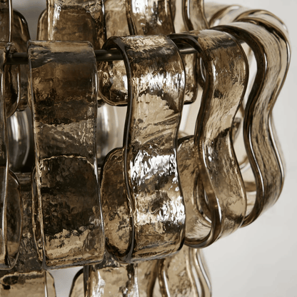 Close-up of a decorative metallic object with wavy design on a white background