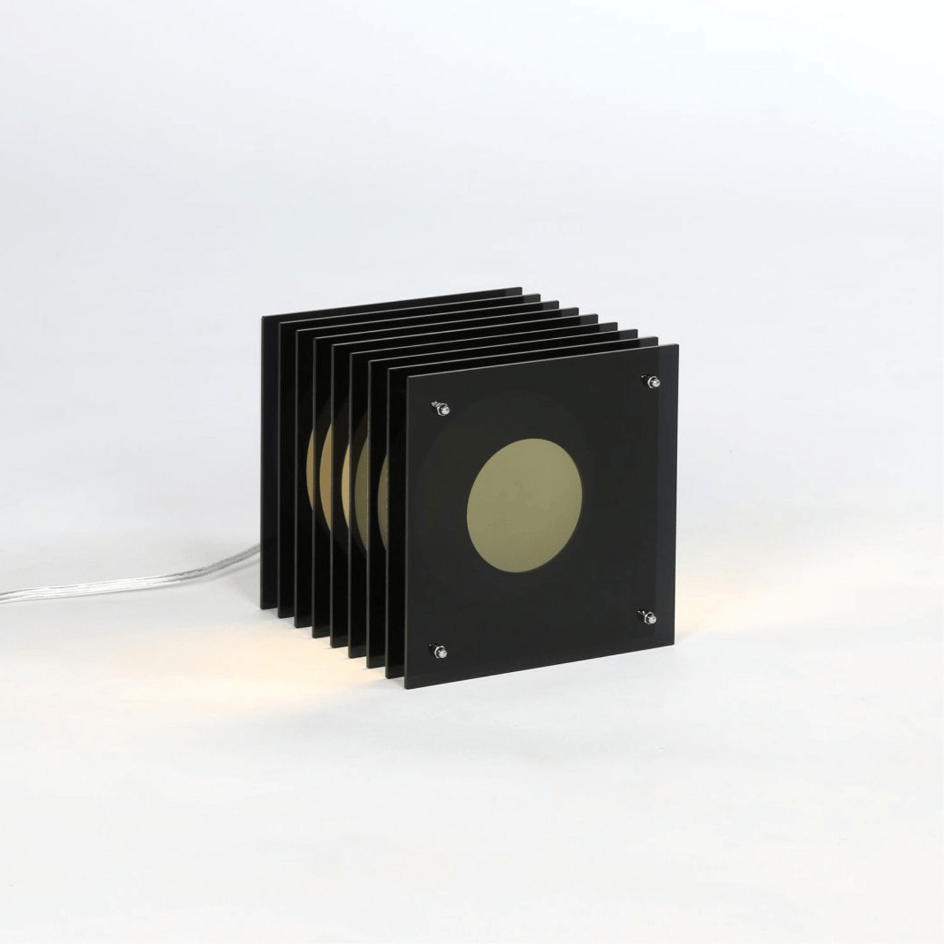 Set of black square coasters with a central circular design on a white background