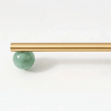Gold rod with a green ball on a white background