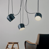 Three pendant lights hanging from the ceiling with a chair and stool in the foreground.