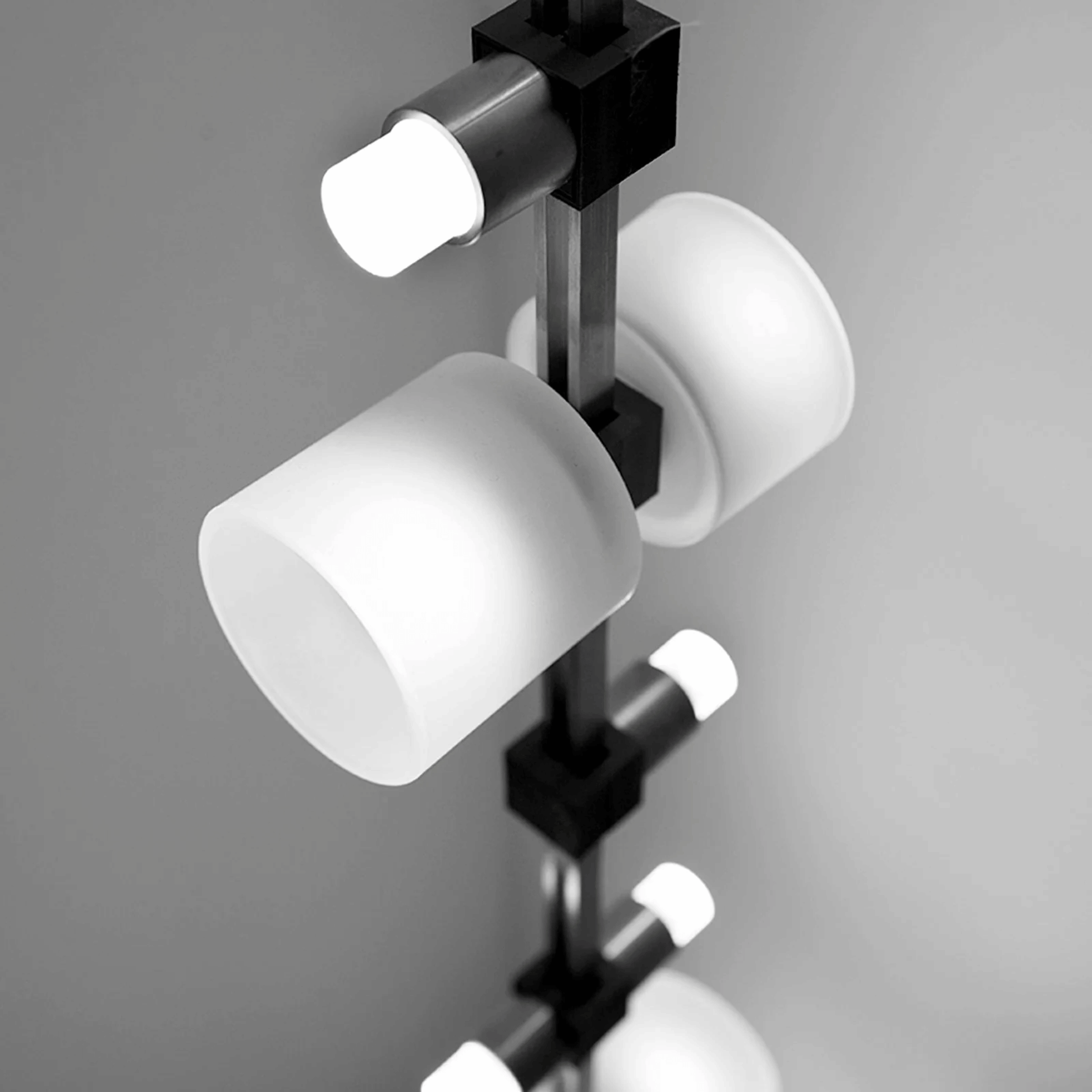 Modern chandelier with white glass shades on a gray background