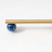 Gold rod with a blue spherical object on a white background