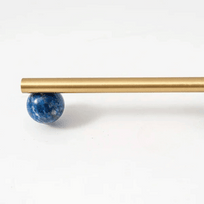 Gold rod with a blue spherical object on a white background
