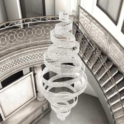 Spiral chandelier hanging in a grand staircase with intricate railings.