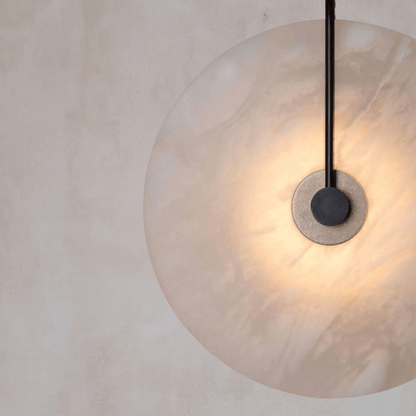 Close-up of a pendant light with a glass shade and black fixture on a neutral background