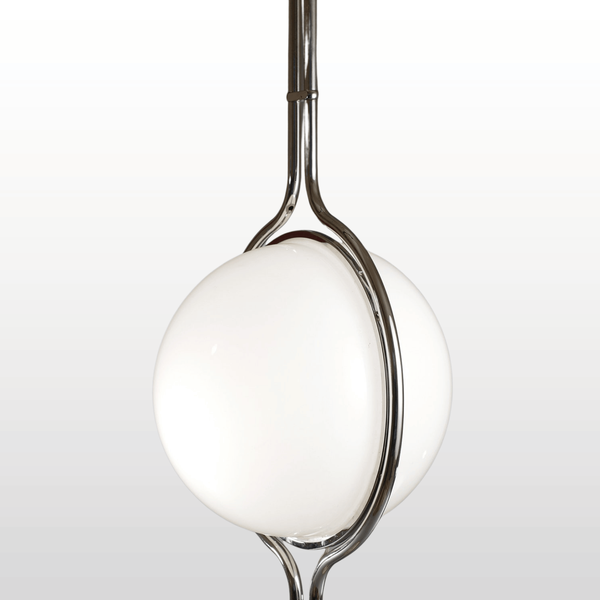 Chrome spoon with a white ceramic bowl on a light gray background