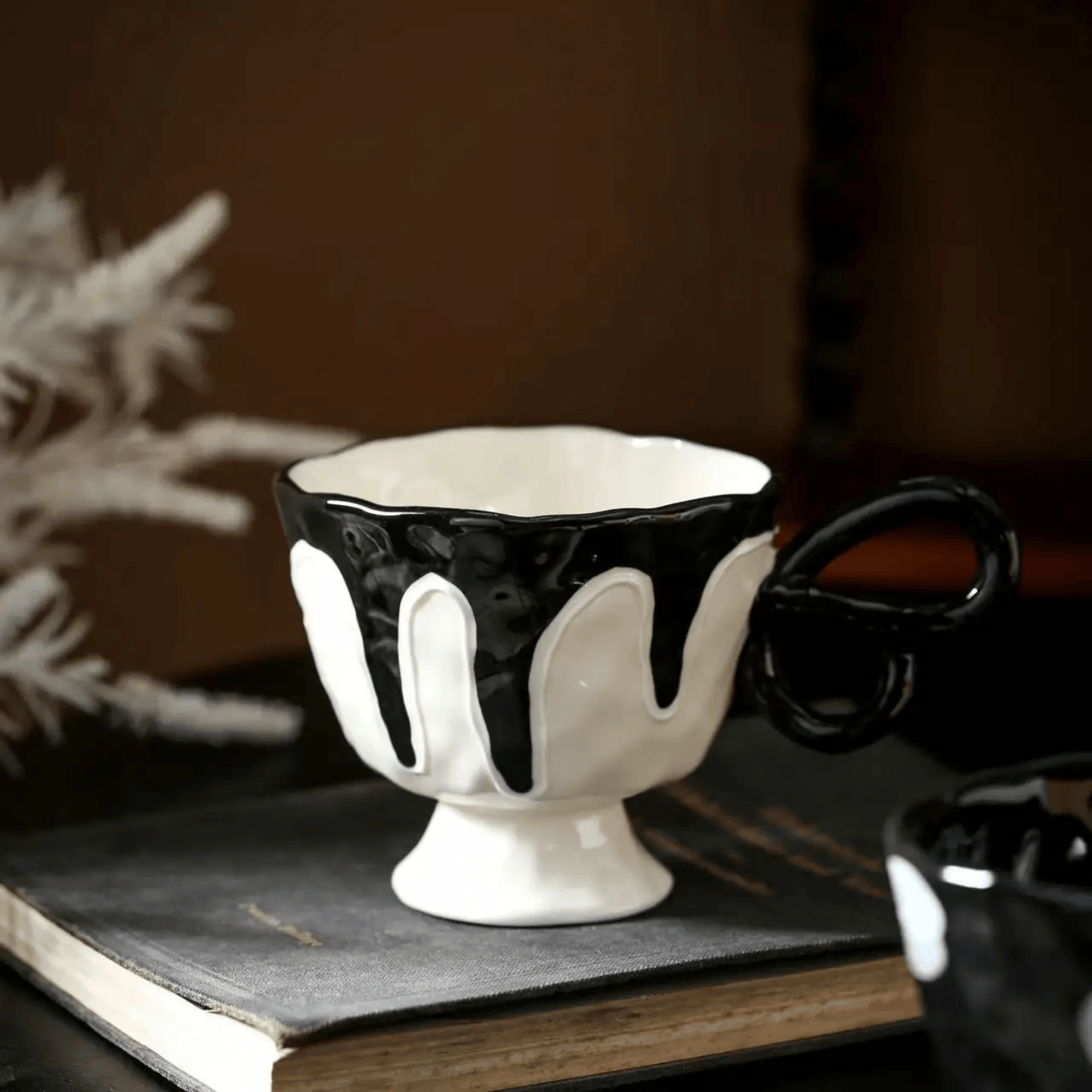 Decorative black and white ceramic bowl on a dark surface with a blurred background