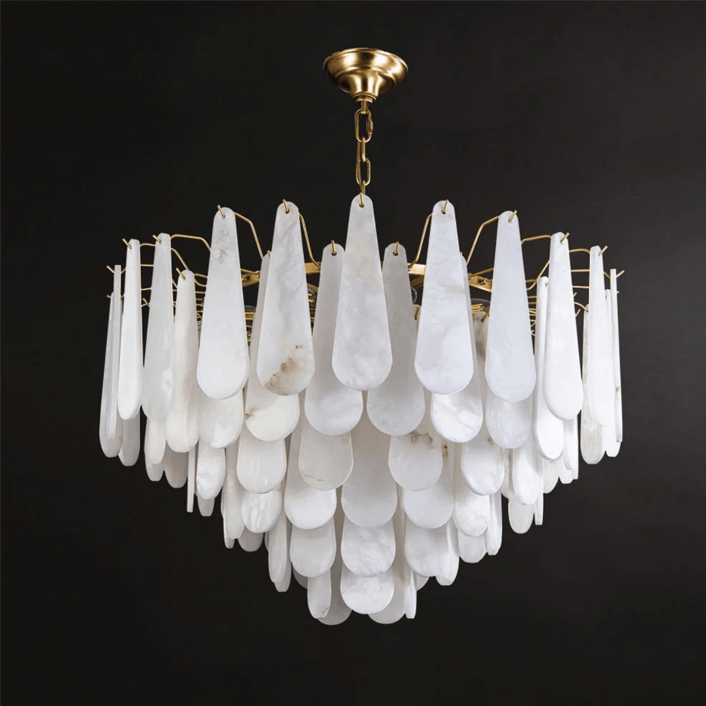 Chandelier with white teardrop-shaped glass and gold fixture on a black background