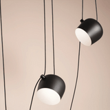 Two black pendant lights with white bulbs on a beige background