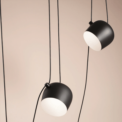 Two black pendant lights with white bulbs on a beige background