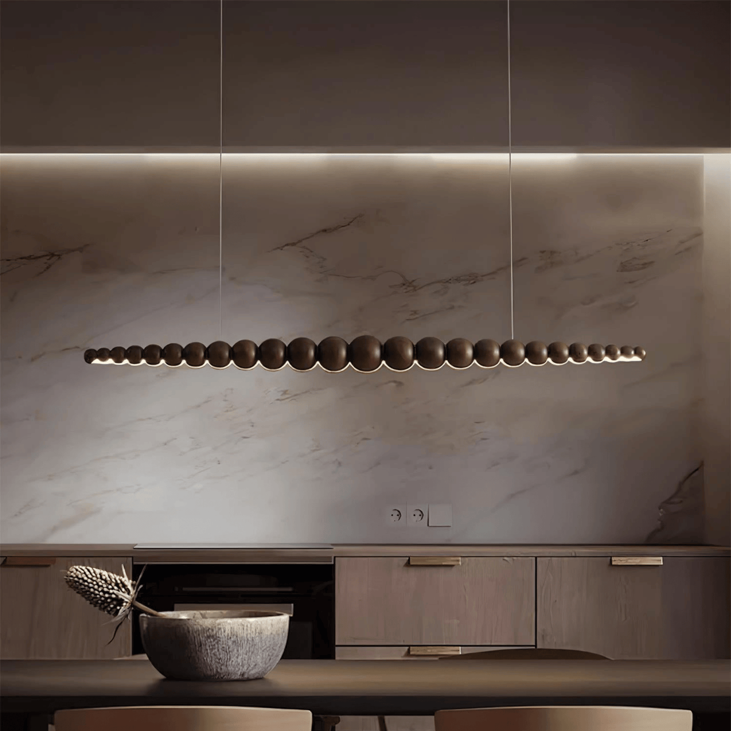 Modern kitchen with marble backsplash and pendant light fixture.