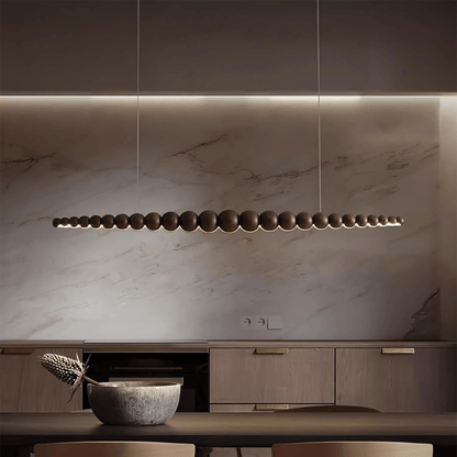 Modern kitchen with marble backsplash and pendant light fixture.