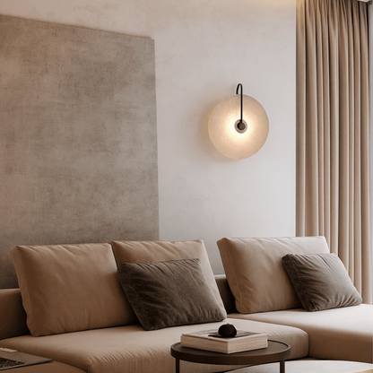 Modern living room with beige sofa, wall lamp, and curtains.