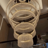 Luxurious chandelier with multiple rings hanging in a room.