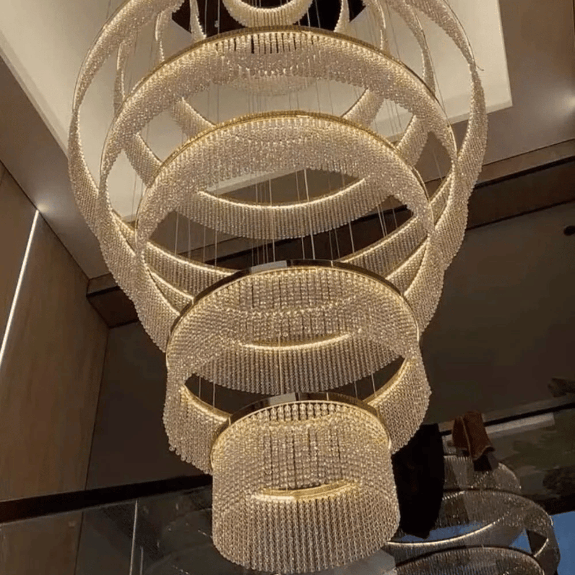 Luxurious chandelier with multiple rings hanging in a room.