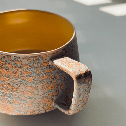 Ceramic mug with a textured handle and interior on a neutral background