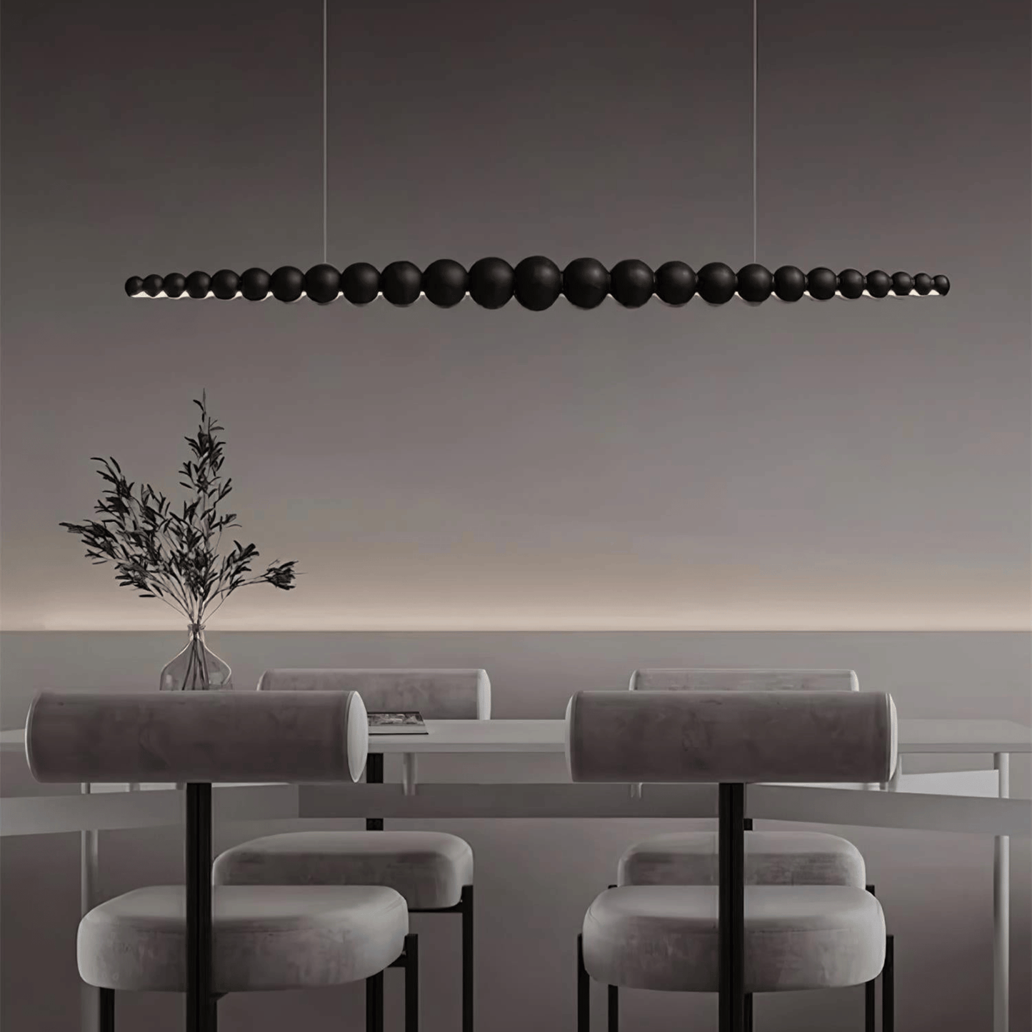 Modern dining area with a long black pendant light fixture.