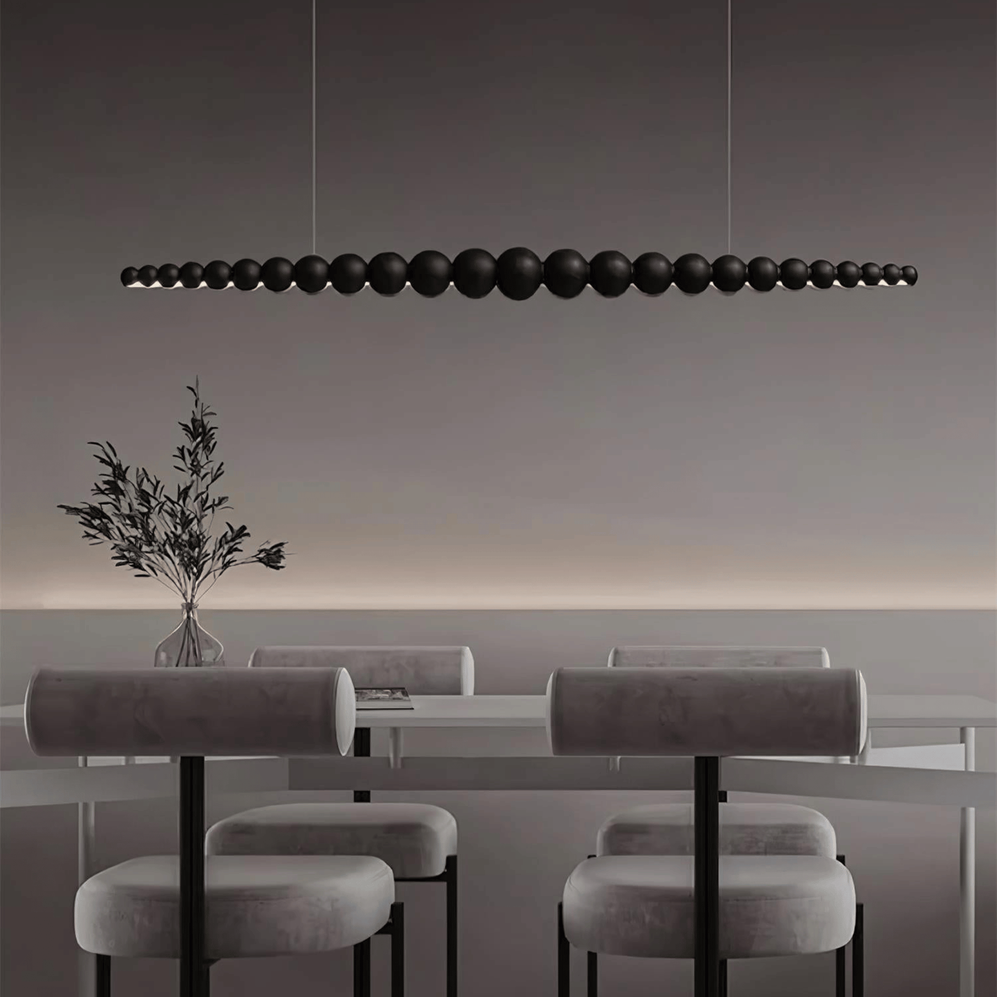 Modern dining area with a long black pendant light fixture.