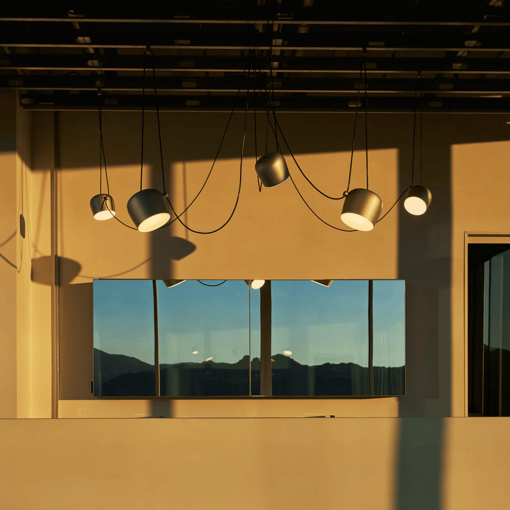 Modern ceiling lights on a beige wall with a reflective surface