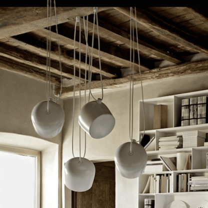 White pendant lights hanging from a wooden ceiling in a modern interior setting.