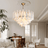 Modern chandelier hanging in a stylish living room with a dining table and chairs.