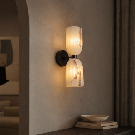 Wall-mounted lamp with glass shades on a neutral wall.