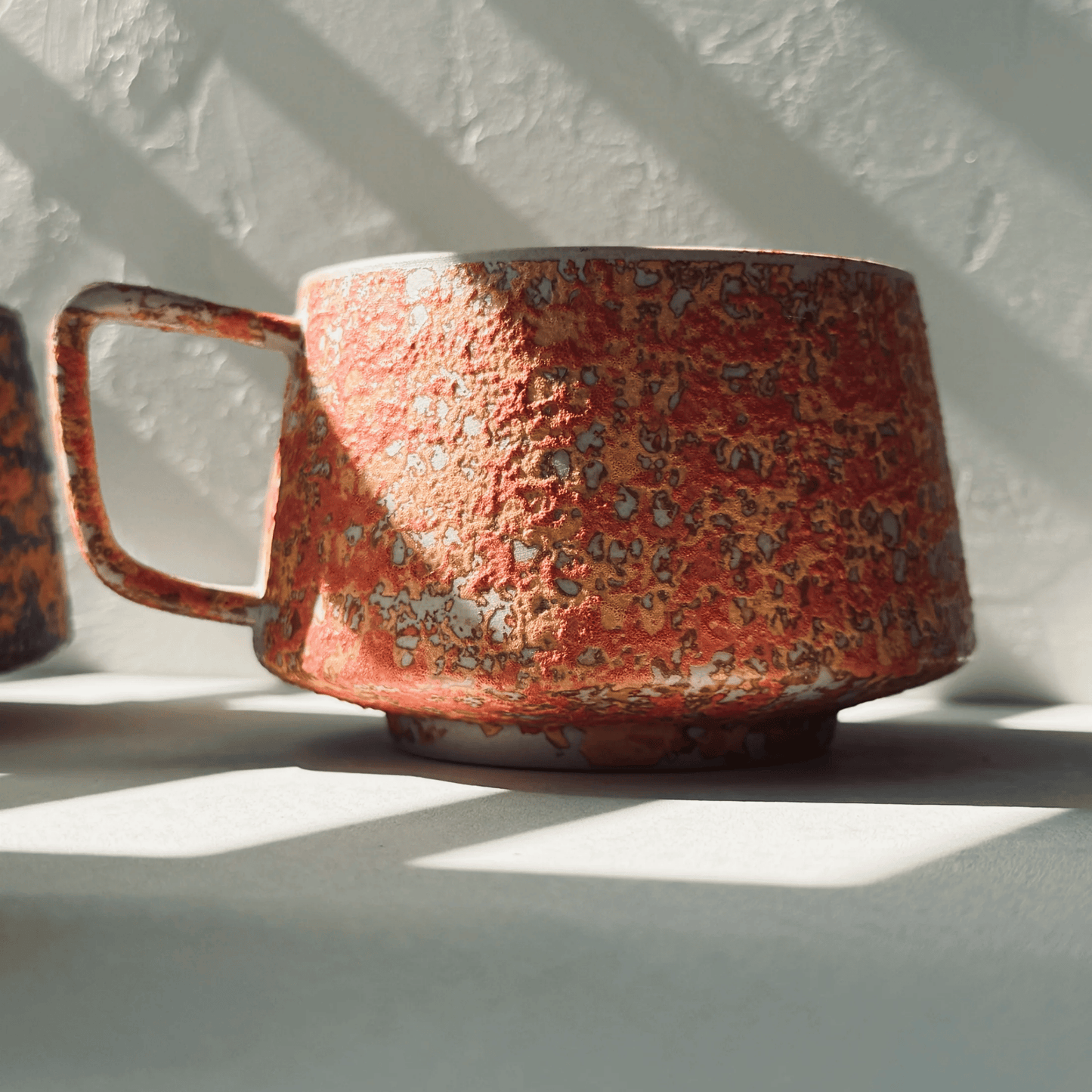 Red ceramic mug with textured surface on a white background