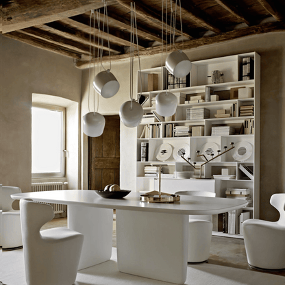 Modern dining room with a white table, chairs, and a bookshelf.