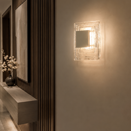 Modern wall sconce lighting fixture on a neutral wall with decorative elements.