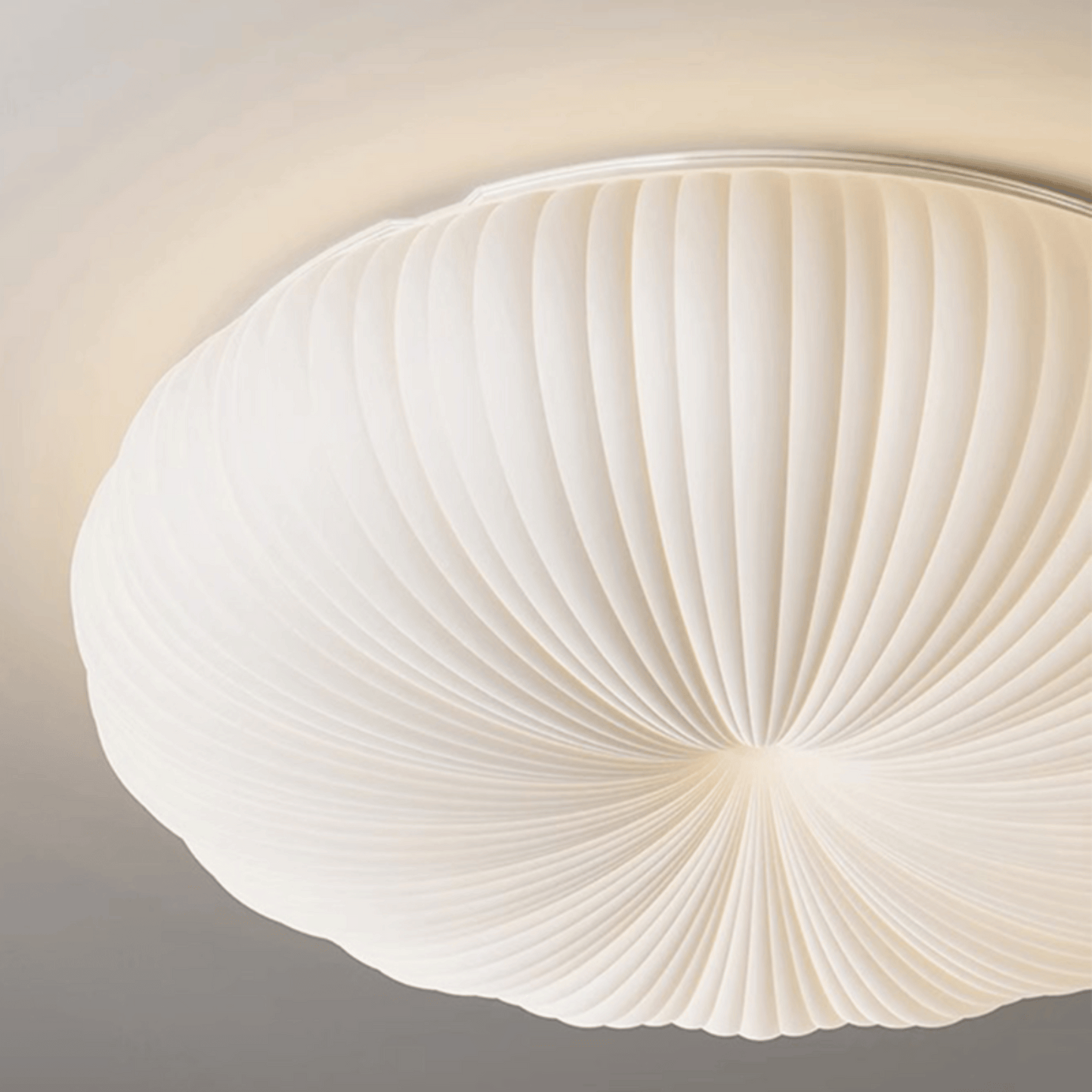 Ceiling light fixture with a white, fan-like design on a neutral background