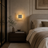 Cozy bedroom with a bed, nightstand, and wall sconce.