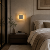 Cozy bedroom with a bed, nightstand, and wall sconce.