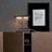 Decorative lamp on a shelf with a framed picture on a gray wall