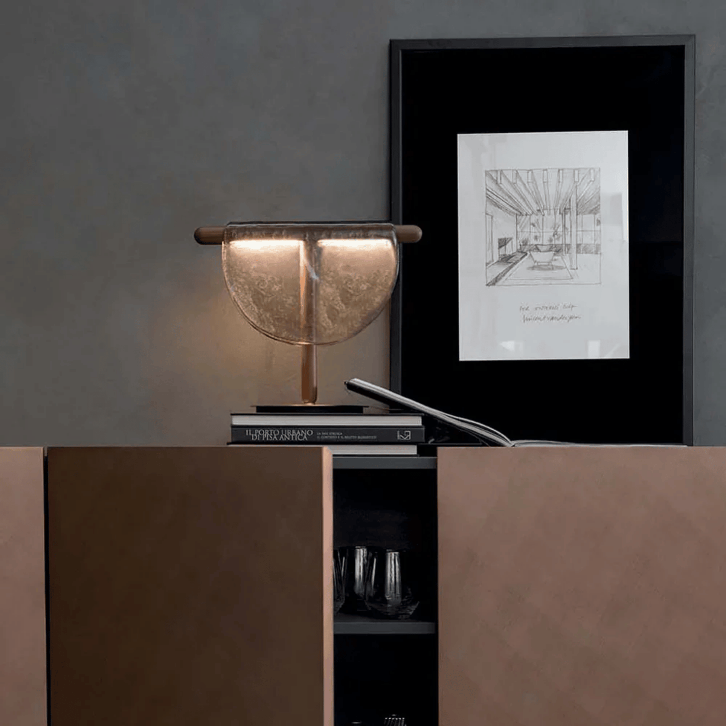 Decorative lamp on a shelf with a framed picture on a gray wall